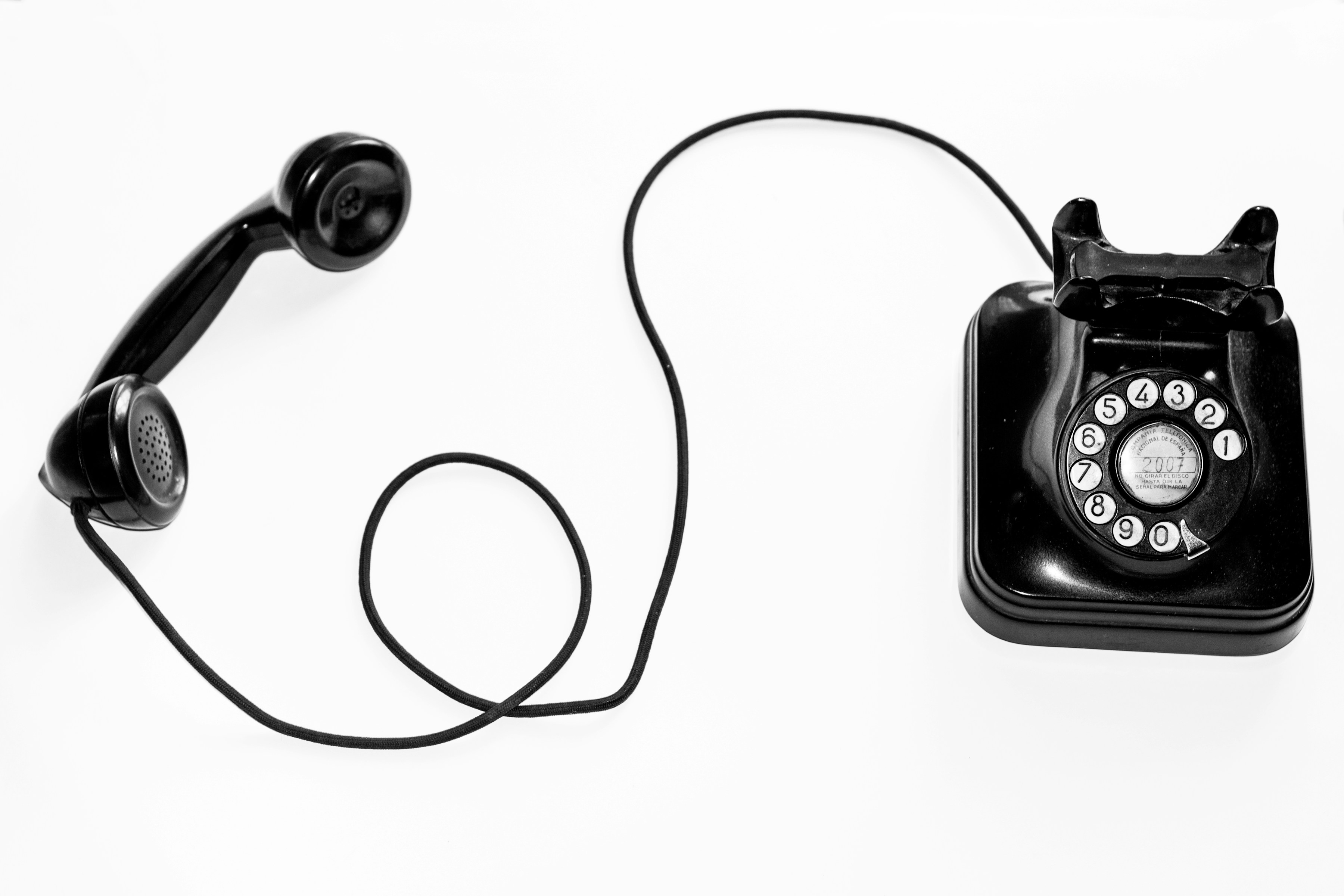 A black telephone with its receiver resting alongside it